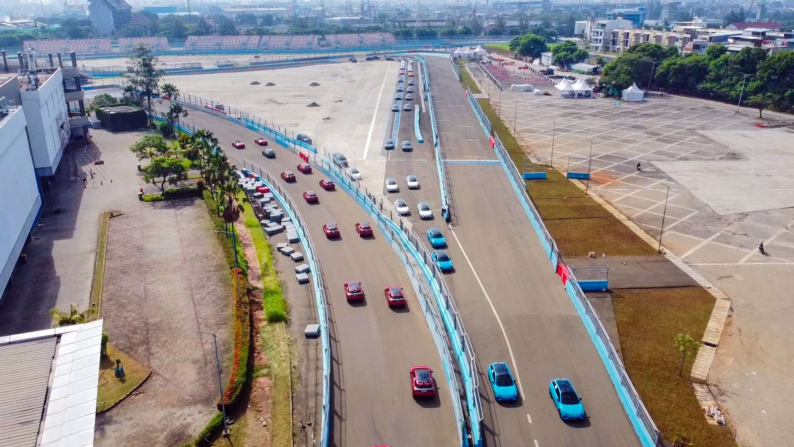 Mobil listrik MG konvoi di sirkuit Formula E Jakarta.